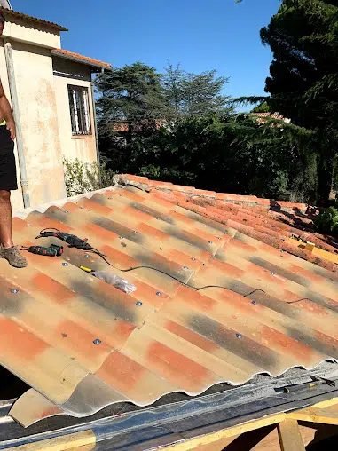 Pose des tuiles canal sur le support par le couvreur